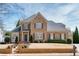 Two-story brick home featuring a manicured lawn, brick stairs, and gray shutters at 5029 Tarry Glen Dr, Suwanee, GA 30024