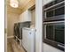 Bright laundry room featuring new washer and dryer, plus modern cabinetry at 5029 Tarry Glen Dr, Suwanee, GA 30024