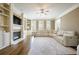 Elegant living room with a fireplace, built-in shelving, hardwood floors, and a large sectional sofa at 5029 Tarry Glen Dr, Suwanee, GA 30024