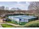 Community tennis courts surrounded by greenery, lit with lampposts at 5029 Tarry Glen Dr, Suwanee, GA 30024