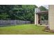 Large, grassy backyard with a privacy fence and a covered outdoor fireplace; perfect for entertaining guests at 207 Birchwood Dr, Loganville, GA 30052