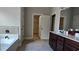 Bathroom with tiled floors, double vanity sinks, a tub, and a separate walk-in closet at 207 Birchwood Dr, Loganville, GA 30052
