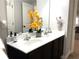 Bathroom featuring double sinks with crystal knobs and an arrangement of yellow flowers on a light-colored countertop at 207 Birchwood Dr, Loganville, GA 30052