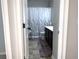 Bathroom with dual-tone flooring, a white toilet, a black vanity, a patterned shower curtain, and light gray walls at 207 Birchwood Dr, Loganville, GA 30052