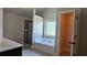 Bathroom with a tub, tiled walls, a window for natural light, and an open doorway at 207 Birchwood Dr, Loganville, GA 30052