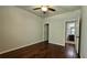 Neutral bedroom with a ceiling fan, hardwood floors, and easy access to the bathroom at 207 Birchwood Dr, Loganville, GA 30052