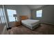Bedroom featuring neutral walls, two windows, carpeted floor, and bed with nightstand at 207 Birchwood Dr, Loganville, GA 30052
