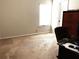 Bedroom with neutral carpet and walls, good light, a desk and chair, and an armoire at 207 Birchwood Dr, Loganville, GA 30052