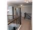 Upstairs hallway with beautiful decorative railing, light gray walls and white trim, and views into multiple rooms at 207 Birchwood Dr, Loganville, GA 30052