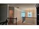 Upstairs hallway featuring carpet, decorative chandelier, and view of laundry room and railing at 207 Birchwood Dr, Loganville, GA 30052