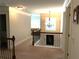 View of an upstairs hallway with decorative railing, chandelier lighting, and natural light from a window at the end of the hall at 207 Birchwood Dr, Loganville, GA 30052