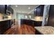 Spacious kitchen featuring stainless appliances, dark wood cabinets, granite counters, and a view into the living area at 207 Birchwood Dr, Loganville, GA 30052