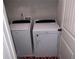 Bright laundry room features a white, modern washer and dryer, and a red patterned floor at 207 Birchwood Dr, Loganville, GA 30052