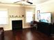 Bright living room featuring a fireplace, hardwood floors, and a large TV at 207 Birchwood Dr, Loganville, GA 30052