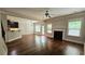 Living room with hardwood floors, fireplace, kitchen access, and natural light from windows and a glass door at 207 Birchwood Dr, Loganville, GA 30052