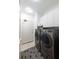 Modern laundry room with front-load washer and dryer, sleek cabinets, and stylish geometric floor tiles at 2500 Peachtree Nw Rd # 605S, Atlanta, GA 30305