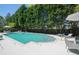 Community pool with chaise lounges, a dining table, and lush greenery at 2500 Peachtree Nw Rd # 605S, Atlanta, GA 30305