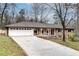 Traditional brick house with a long driveway, a white garage door, and a quaint front porch at 2722 Oswood Dr, Tucker, GA 30084