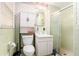 Mint-green bathroom featuring a shower, decorative wallpaper, cabinet storage and sink at 7121 Forest Se Dr, Covington, GA 30014