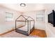 Light-filled bedroom with a cute canopy bed frame, hardwood floors, and paneled walls at 7121 Forest Se Dr, Covington, GA 30014