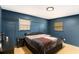 Cozy bedroom featuring a blue accent wall, carpet flooring, and ample natural light from two windows at 7121 Forest Se Dr, Covington, GA 30014