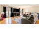 Sunlit living room featuring hardwood floors, a large TV, reclining sofas, and access to an outdoor patio at 7121 Forest Se Dr, Covington, GA 30014