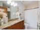 Bathroom with granite countertops, wood cabinetry, and a tiled shower behind glass at 1253 Caroline Ne St, Atlanta, GA 30307
