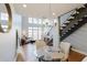 Charming dining room with a glass table, staircase, modern light fixture, and hardwood flooring at 1253 Caroline Ne St, Atlanta, GA 30307