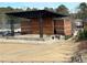 Exterior view of an amphitheater with brick walls, a stage, a metal canopy, and seating on grassy slopes at 514 Lovinggood Ct, Woodstock, GA 30189