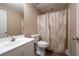 Bathroom featuring modern sink vanity, toilet, and tiled shower with a decorative shower curtain at 514 Lovinggood Ct, Woodstock, GA 30189