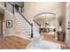 Elegant foyer with hardwood floors, staircase with black accents, and arched entryway to the dining area at 514 Lovinggood Ct, Woodstock, GA 30189