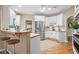 Bright kitchen features white cabinets, stainless steel appliances, and a breakfast bar with wooden stools at 514 Lovinggood Ct, Woodstock, GA 30189