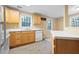 Cozy kitchen boasts wooden cabinets, white countertops, and modern appliances with plenty of natural light at 514 Lovinggood Ct, Woodstock, GA 30189