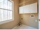 Bright laundry room featuring white cabinets and a window with a view of the outdoors at 514 Lovinggood Ct, Woodstock, GA 30189