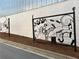 A black iron musical art display located on the side of a street near a white brick wall and a sidewalk at 514 Lovinggood Ct, Woodstock, GA 30189