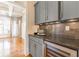 Stylish bar area showcasing gray cabinets, a wine cooler, and elegant countertops with a decorative backsplash at 2629 Apple Valley Ne Rd, Brookhaven, GA 30319