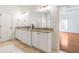 Bright bathroom with granite counters, double sinks, white cabinetry, and tiled flooring at 2629 Apple Valley Ne Rd, Brookhaven, GA 30319