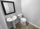 Simple powder room featuring a pedestal sink, toilet, and tile flooring in a clean, modern style at 3519 Cast Palm Dr, Buford, GA 30519