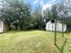 Expansive backyard featuring lush green grass, mature trees, and a storage shed, perfect for outdoor activities at 961 Kingston Nw Rd, Conyers, GA 30012