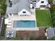 Stunning aerial view of a home with a pool, patio with lounge chairs, backyard lawn, and an outdoor fire pit at 100 Tuxedo Nw Ter, Atlanta, GA 30342