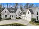 Stunning white home with a circular driveway, manicured landscaping, and an attached three-car garage at 100 Tuxedo Nw Ter, Atlanta, GA 30342
