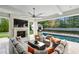 Covered patio featuring a large fireplace, mounted television, fan, in-ground pool, and comfortable seating at 100 Tuxedo Nw Ter, Atlanta, GA 30342