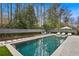 Beautiful pool area with stone patio, lounge chairs, and well-manicured landscaping at 100 Tuxedo Nw Ter, Atlanta, GA 30342
