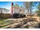 A spacious backyard featuring mature trees, a brick chimney, and a wood privacy fence at 1394 Meadow Springs Dr, Lilburn, GA 30047