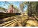 Spacious backyard featuring a brick chimney, lush trees, and perimeter fence at 1394 Meadow Springs Dr, Lilburn, GA 30047