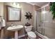 This bathroom offers a pedestal sink, framed mirror, toilet and a glass enclosed shower at 1394 Meadow Springs Dr, Lilburn, GA 30047