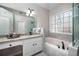 Bright bathroom featuring granite countertops, tiled walls, and an elegant soaking tub at 1394 Meadow Springs Dr, Lilburn, GA 30047
