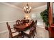 Elegant dining room with a polished wood table, chandelier, and large window at 1394 Meadow Springs Dr, Lilburn, GA 30047