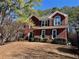 Charming two-story brick home with black shutters and a beautifully landscaped front yard on a sunny day at 1394 Meadow Springs Dr, Lilburn, GA 30047