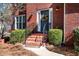 Close-up of a beautiful brick home entrance with a decorated front door and manicured bushes at 1394 Meadow Springs Dr, Lilburn, GA 30047